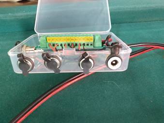 A plastic box with wires and switches

Description automatically generated